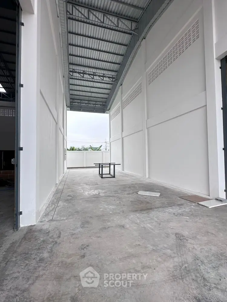 Spacious industrial warehouse with high ceilings and open layout, ideal for storage or manufacturing.