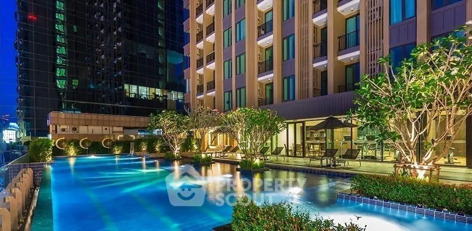Luxurious condominium with stunning pool and lush greenery at night