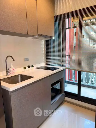 Modern kitchen with sleek cabinetry and large window for natural light