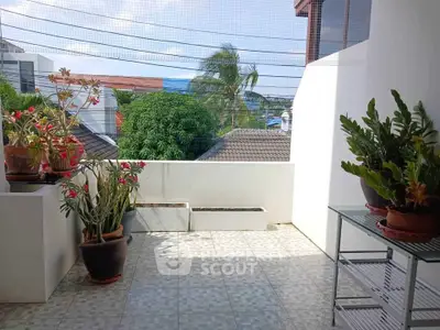 Spacious balcony with potted plants and scenic view, perfect for relaxation.