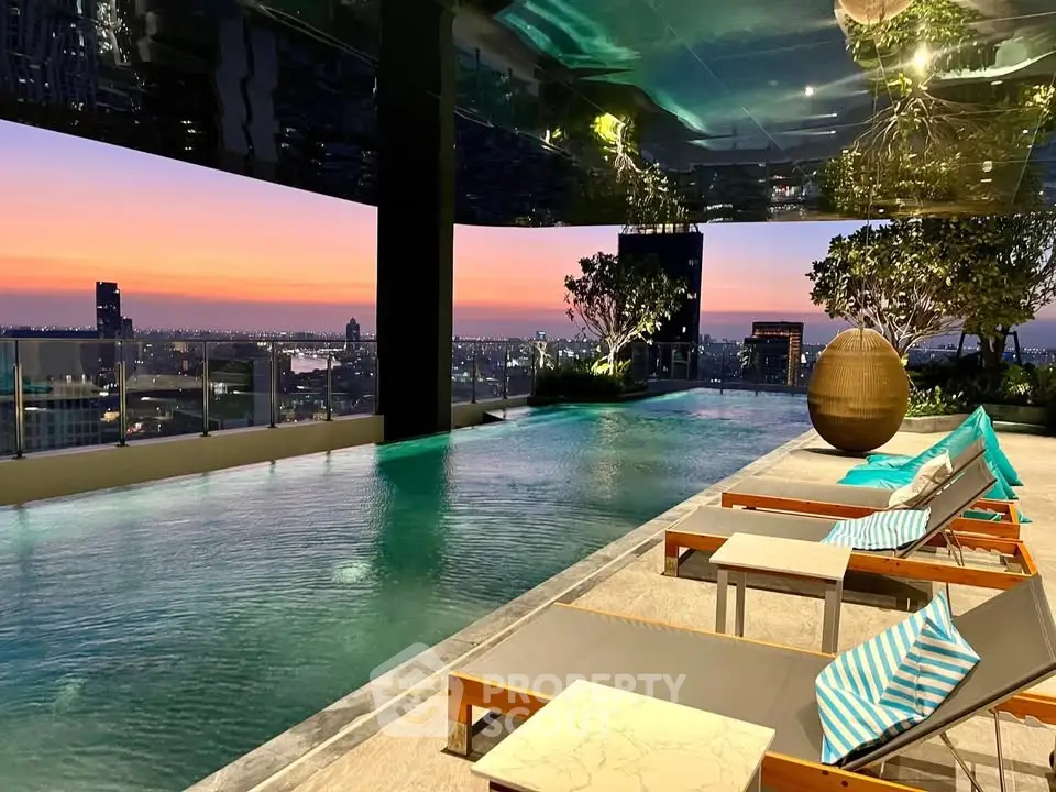 Luxurious rooftop pool with stunning city skyline views at sunset, featuring modern lounge chairs and lush greenery.
