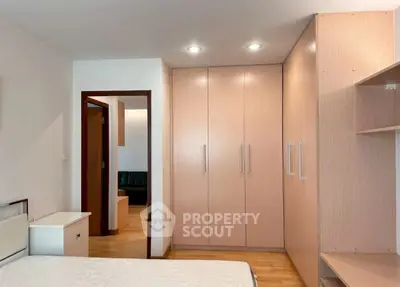 Spacious bedroom with built-in wardrobe and modern lighting