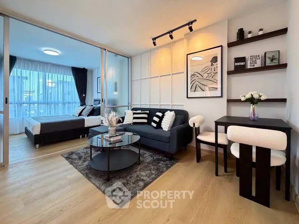 Modern open-plan living room with stylish decor and cozy bedroom area