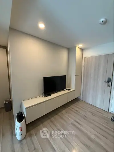 Modern living room with sleek TV setup and wooden flooring