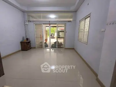 Spacious unfurnished room with large windows and tiled flooring, ideal for customization.