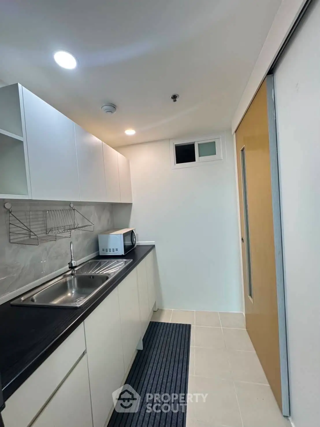 Modern kitchen with sleek cabinetry and stainless steel sink in a compact layout.