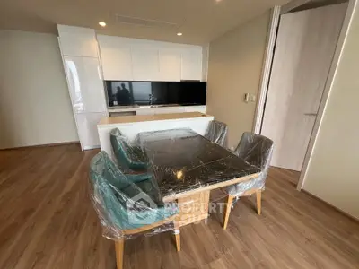 Modern dining area with sleek kitchen and wooden flooring in a stylish apartment.