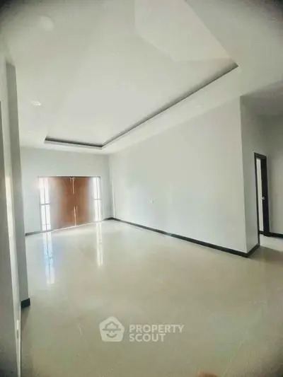 Spacious empty room with modern ceiling design and large windows