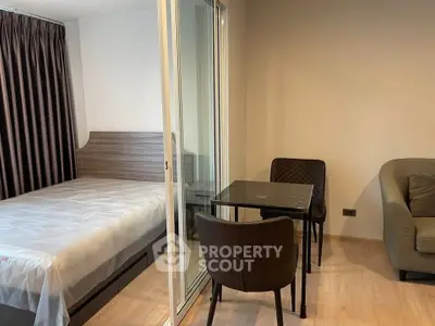 Modern studio apartment with cozy bedroom and dining area, featuring sleek furniture and natural light.