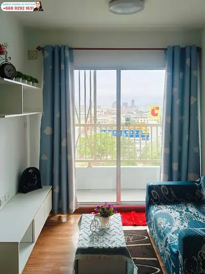 Charming living room with balcony view in modern condo, featuring cozy decor and ample natural light.