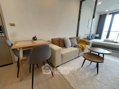 Modern living room with cozy seating and stylish decor in open-concept apartment.