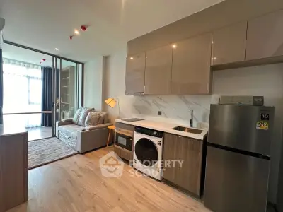 Modern open-plan kitchen and living room with sleek appliances and stylish decor.