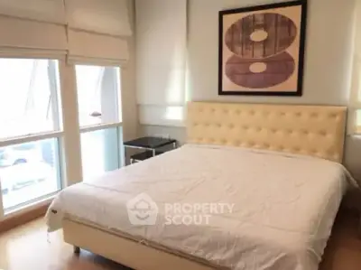 Spacious bedroom with large windows and modern decor in a luxury apartment.