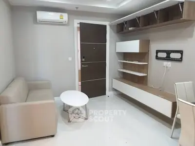 Modern living room with sleek furniture and wall-mounted storage in a minimalist design.