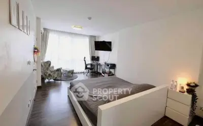 Spacious modern bedroom with stylish decor and natural light, perfect for relaxation and comfort.