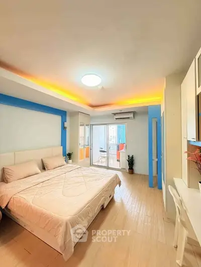Spacious bedroom with modern decor and balcony access in a stylish apartment.
