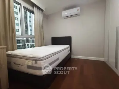 Modern bedroom with large window and air conditioning in urban apartment