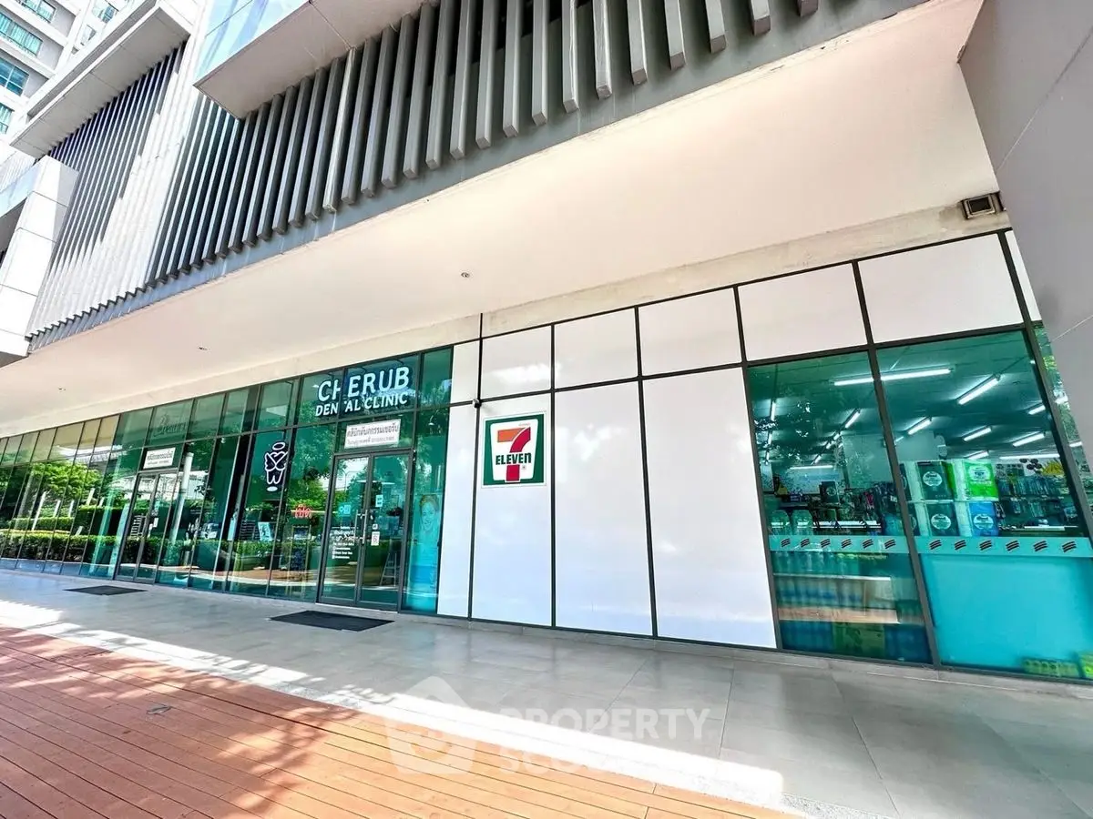 Modern commercial building exterior with glass facade and retail signage.