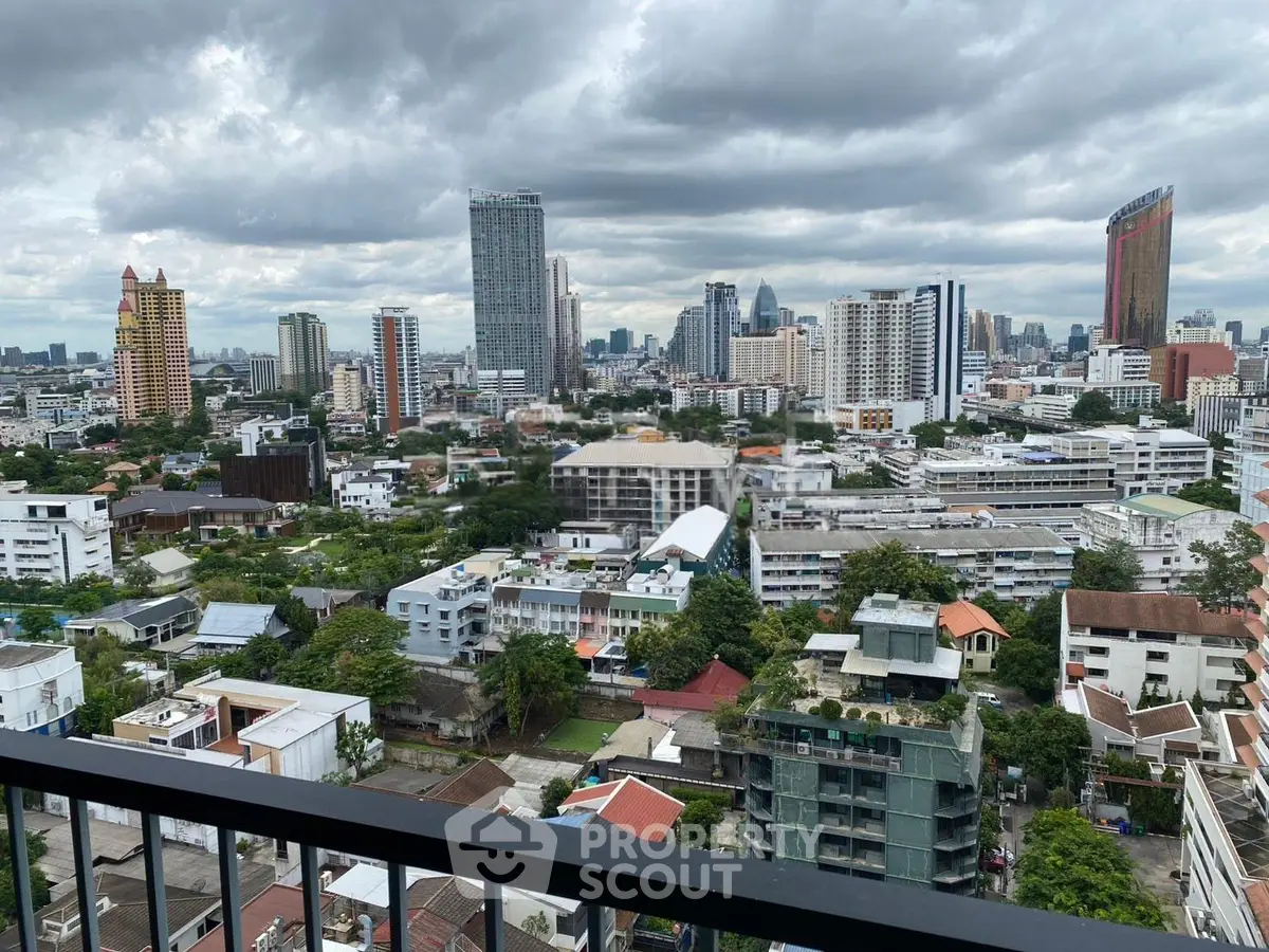 Stunning cityscape view from a high-rise balcony overlooking urban skyline and lush greenery.