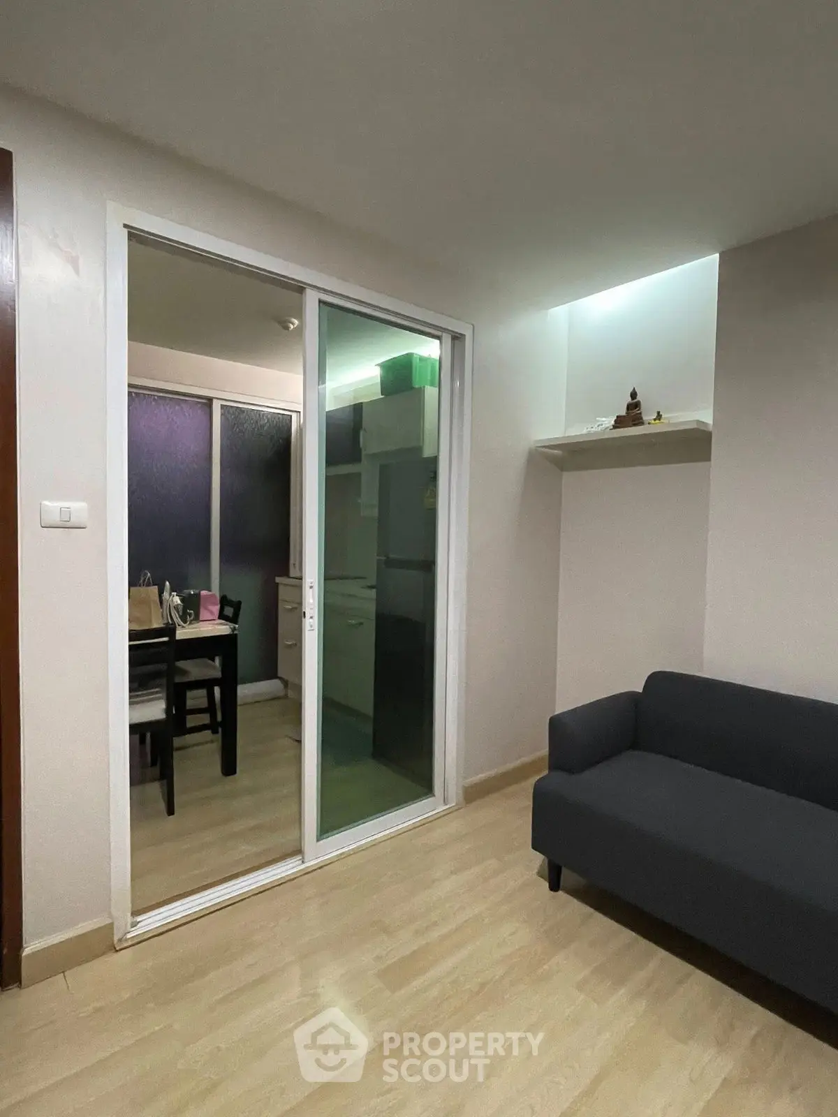 Modern living room with sliding glass doors leading to a cozy dining area and kitchen.