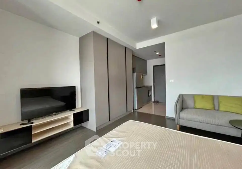 Modern living room with sleek furniture and open kitchen layout in a stylish apartment.