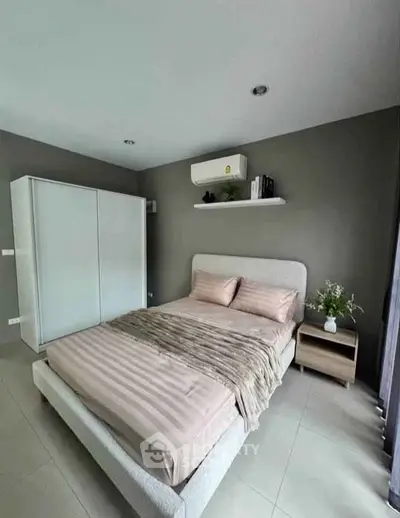 Modern bedroom with stylish decor and air conditioning in a contemporary apartment.