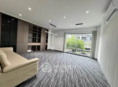 Spacious modern living room with large window and built-in shelving