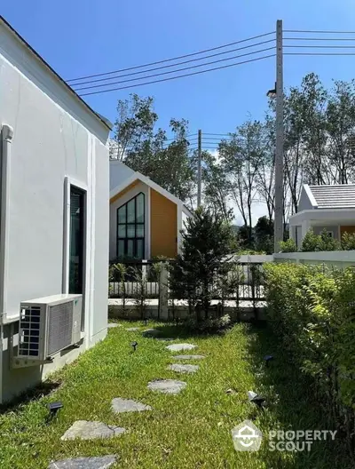 Charming garden view with modern house exterior and lush greenery.