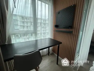 Modern study nook with desk and chair, featuring large window with city view.