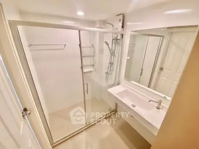 Modern bathroom with glass shower enclosure and sleek sink design