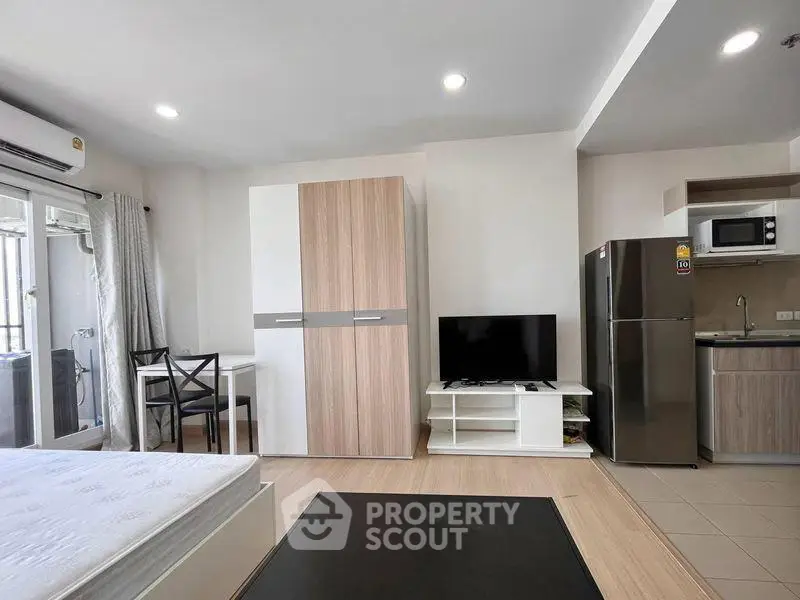 Modern studio apartment with sleek kitchen and cozy living area, perfect for urban living.