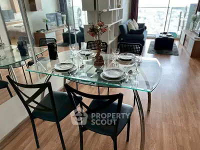 Stylish dining area with glass table in modern apartment, featuring elegant decor and city view.