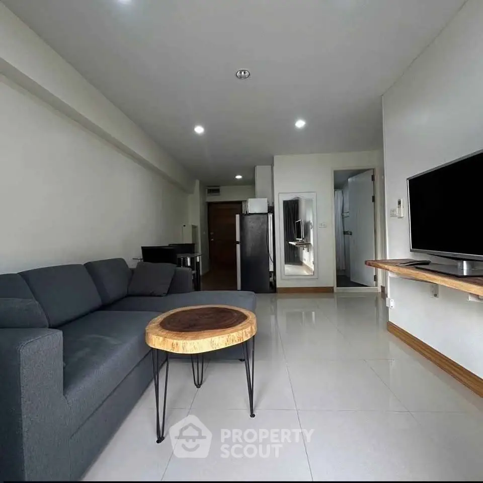Modern living room with sleek furniture and wall-mounted TV in a stylish apartment.