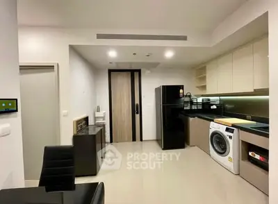 Modern kitchen with sleek appliances and washing machine in stylish apartment.