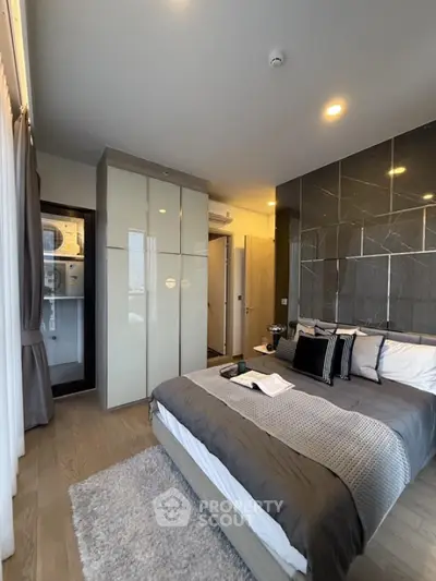 Modern bedroom with stylish decor and built-in wardrobe in a high-rise apartment.