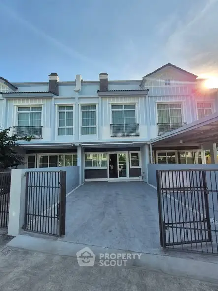 Modern townhouse exterior with gated driveway and large windows