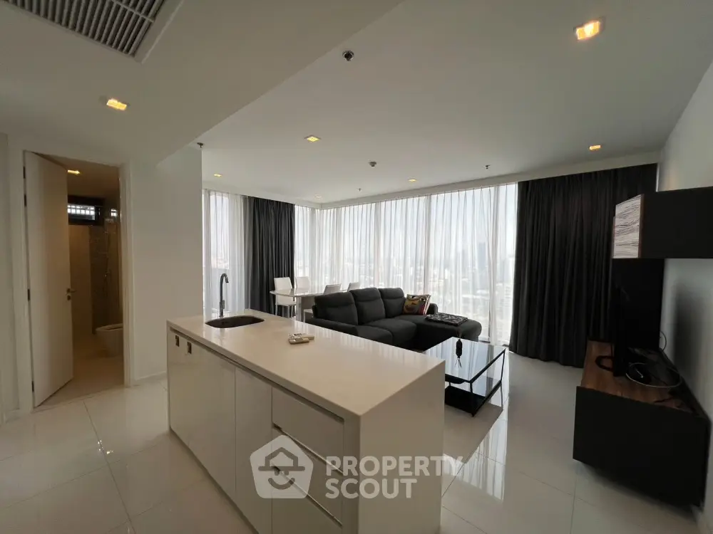 Modern open-plan living room with sleek kitchen and panoramic city views