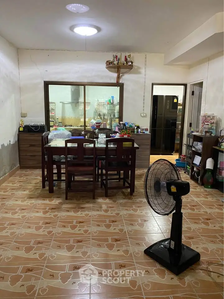 Spacious dining area with tiled flooring and modern appliances, perfect for family gatherings.