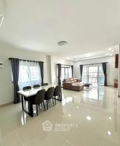 Spacious modern living room with elegant dining area and abundant natural light.