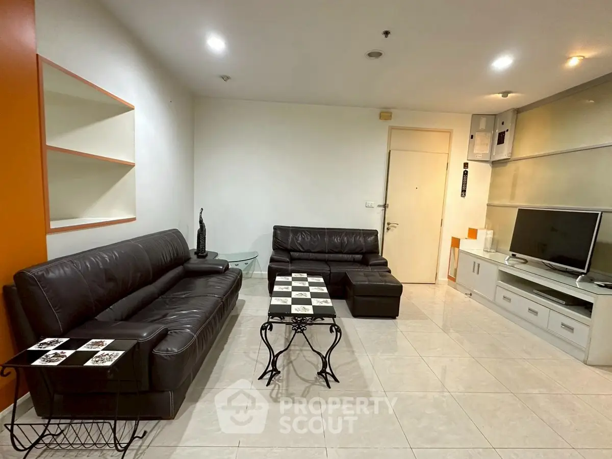 Spacious living room with modern leather sofas and sleek entertainment unit