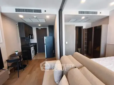 Modern studio apartment with open layout, featuring a cozy living area, compact kitchen, and stylish furnishings.