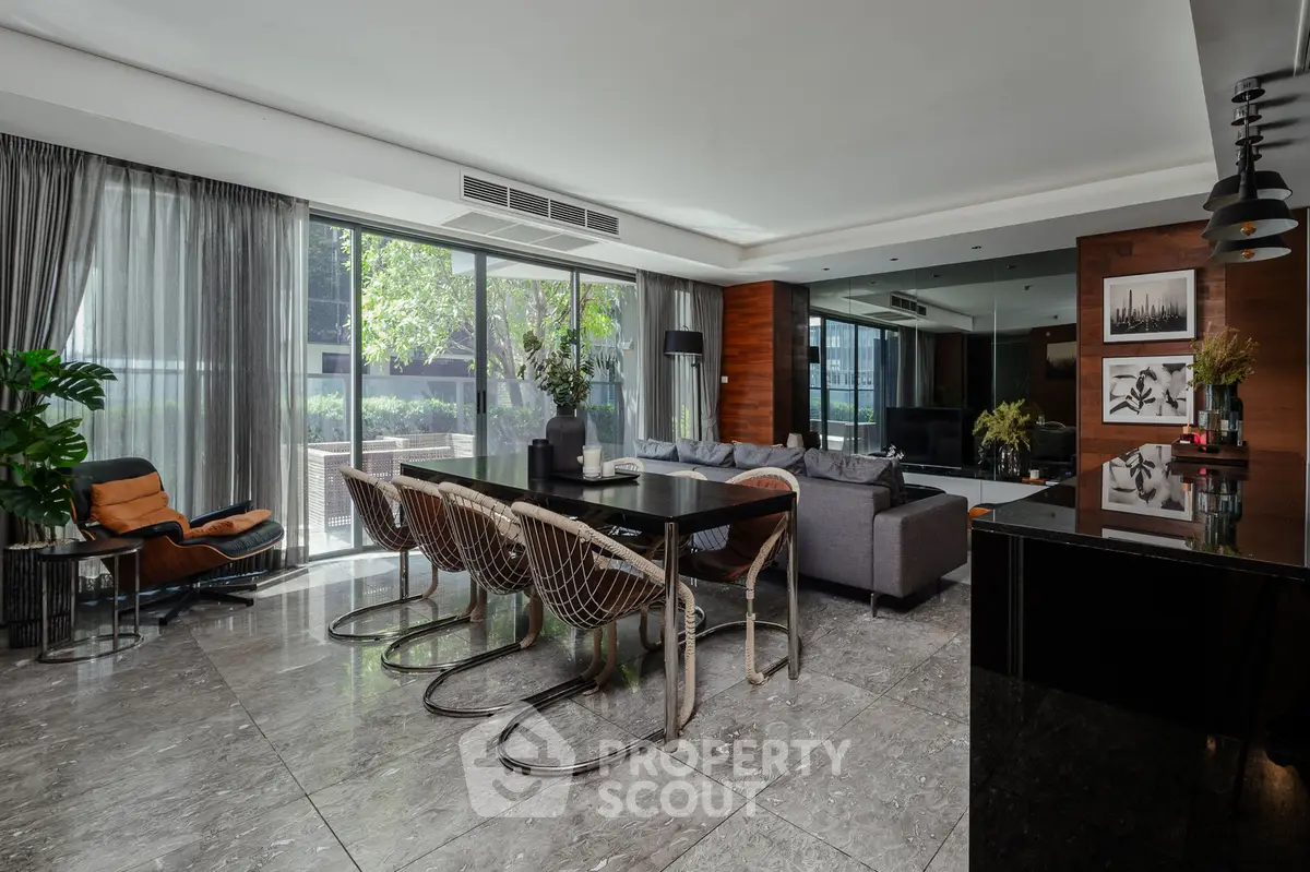 Luxurious open-plan living room with modern decor and large windows offering garden views.