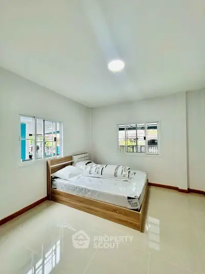 Bright and spacious bedroom with modern design and large windows.