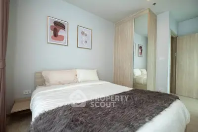 Modern bedroom with stylish decor and cozy ambiance, featuring a plush bed and elegant artwork.