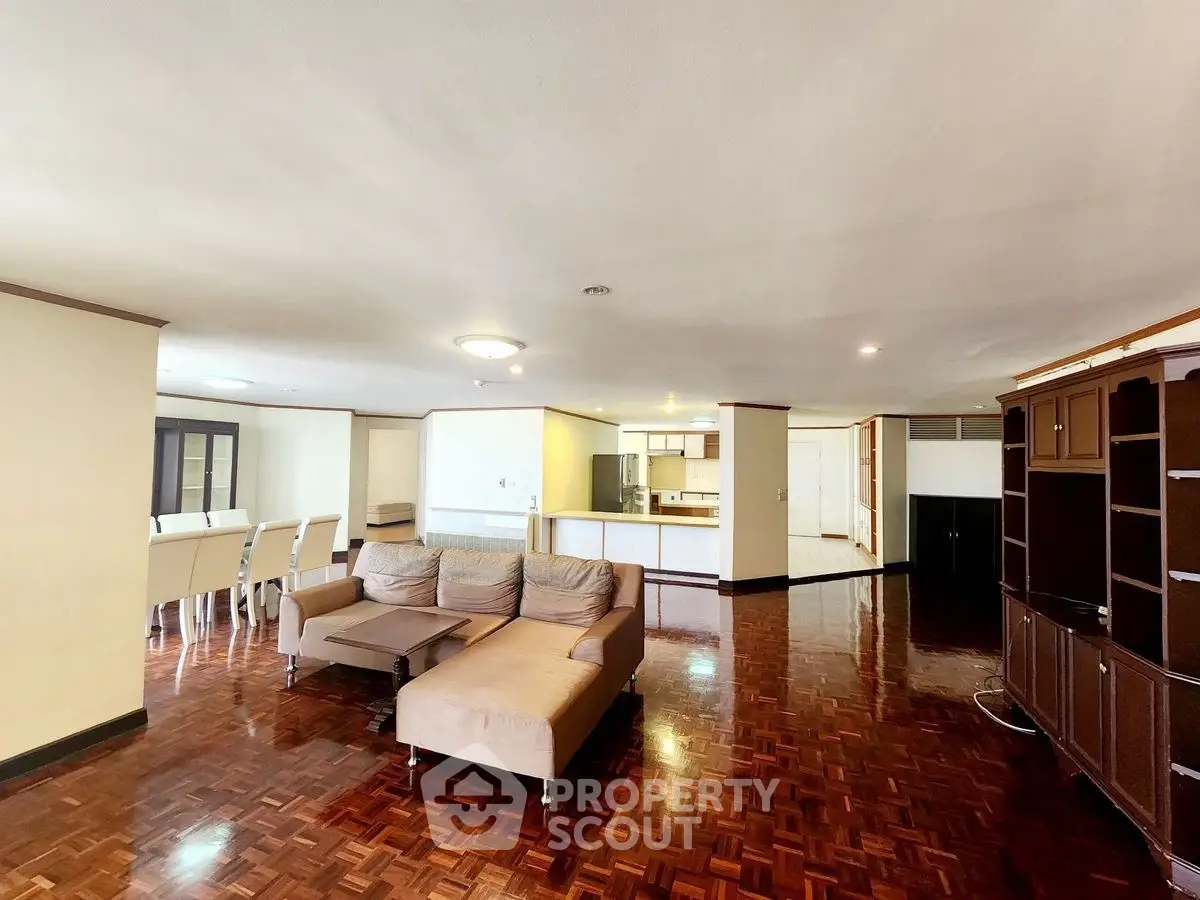 Spacious open-plan living room with elegant parquet flooring and modern furniture