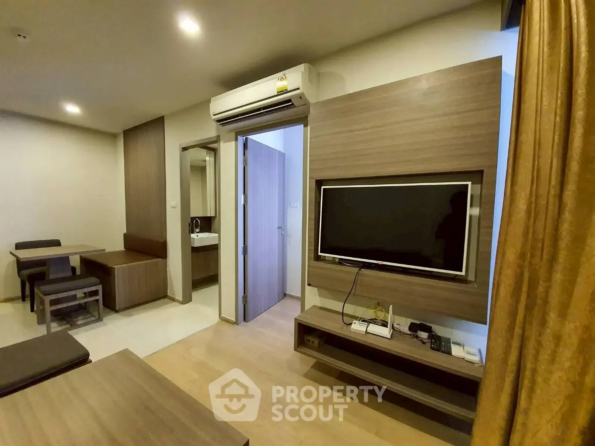 Modern living room with wall-mounted TV and air conditioning in stylish apartment
