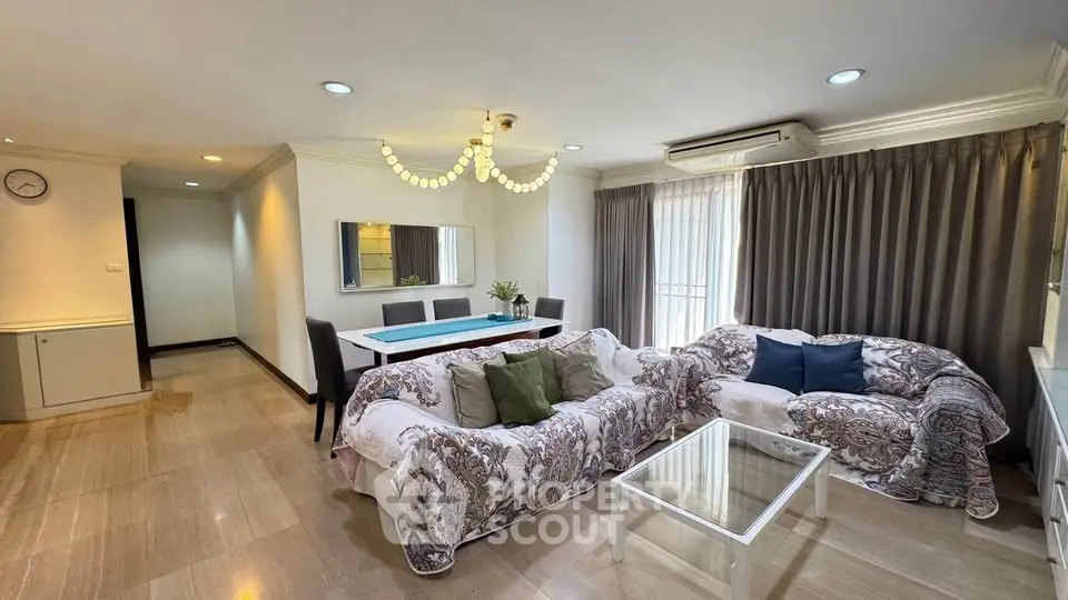 Spacious living room with elegant decor and natural light, featuring comfortable seating and a stylish dining area.