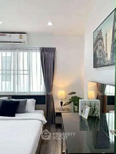 Modern bedroom with stylish decor, large window, and sleek furniture in a cozy apartment.