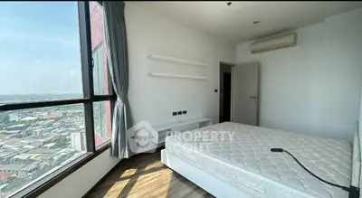 Spacious bedroom with city view and modern amenities in high-rise apartment