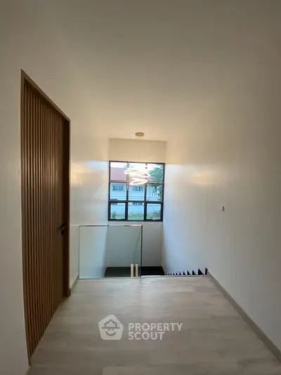 Modern hallway with large window and stylish lighting in contemporary home